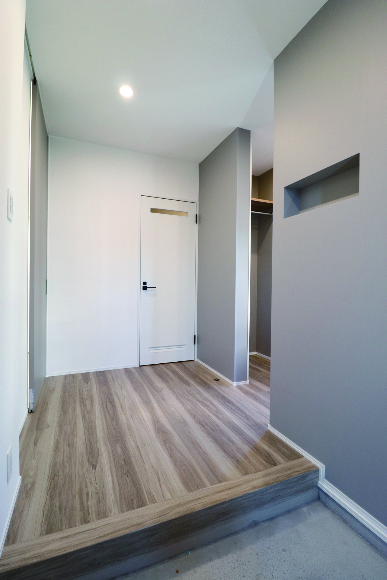 玄関を入るとブルーグレーのクロスとニッチがアクセント。